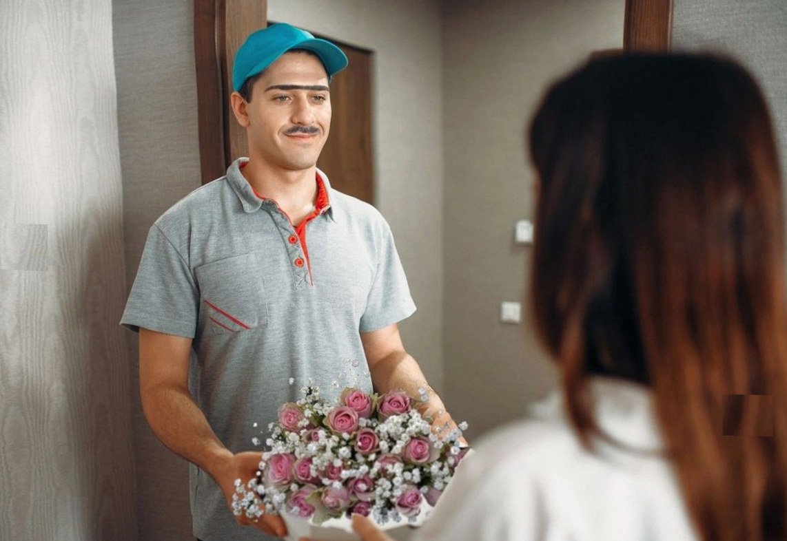 Lieferant überreicht einen Rosenstrauß an der Tür